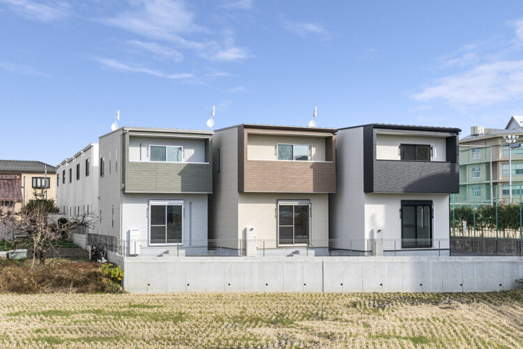 愛知県一宮市の変形地に並ぶナチュラルテイストな戸建賃貸住宅の陽当りの良いベランダのある色違いの外観の戸建賃貸