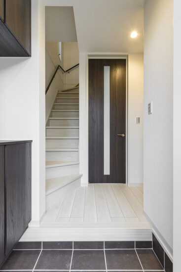 名古屋市西区の各棟のデザインに個性がる戸建賃貸住宅のシューズボックスがあり階段へのアクセスもいい玄関