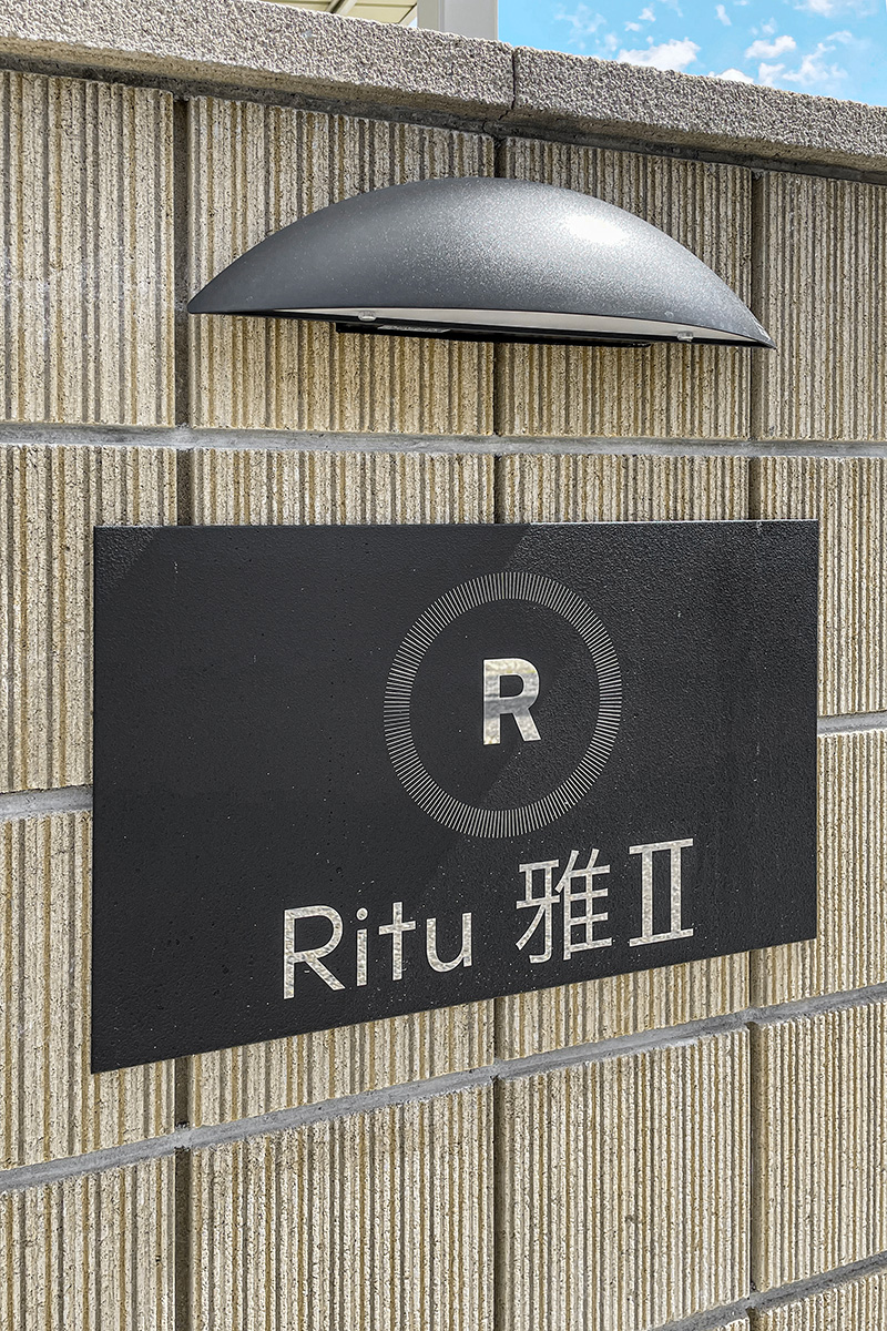 愛知県一宮市のロフト付きメゾネットアパートの夜は上からライトアップされる出入り口付近の見やすい館銘板
