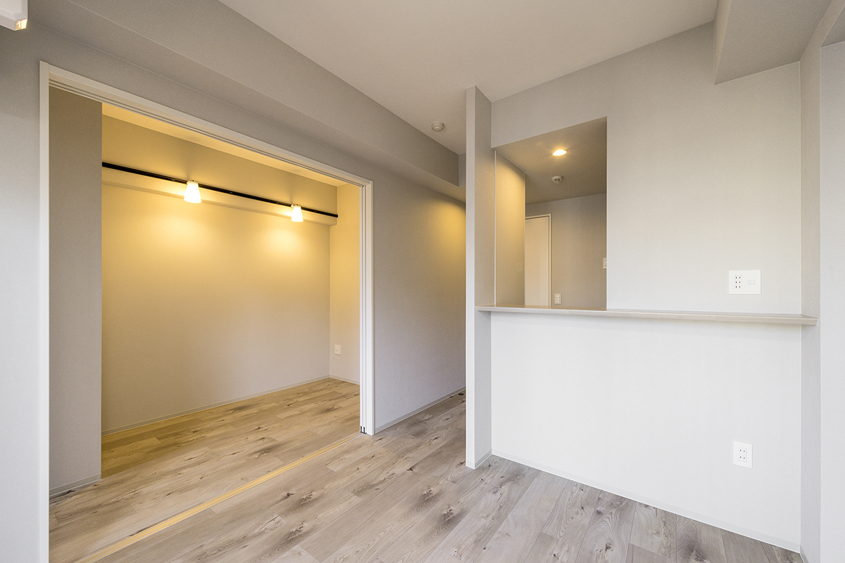 名古屋市中区の約50坪の土地の10階建て賃貸マンションのシンプルなデザインにおしゃれなライトが映える洋室とリビング