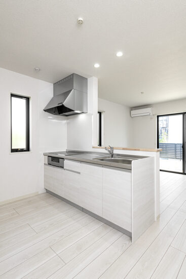 愛知県豊田市の一戸建て賃貸住宅2LDKA棟：IH仕様のキッチン。リビングの窓から明るい光が入ります。