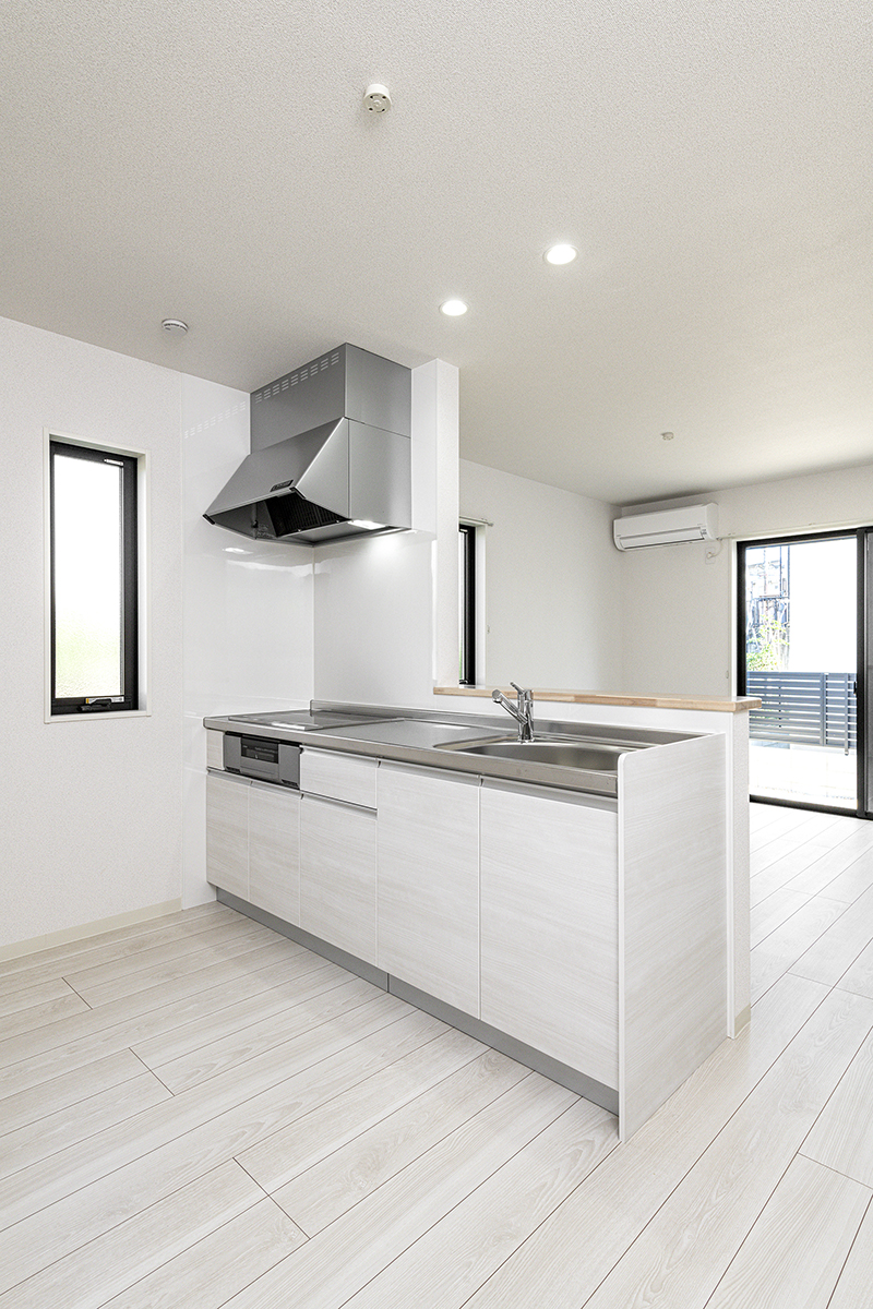 愛知県豊田市の一戸建て賃貸住宅2LDKA棟：IH仕様のキッチン。リビングの窓から明るい光が入ります。