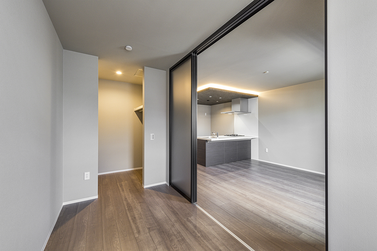 名古屋市名東区の約80坪の土地のLDKの扉を開けると広さを感じるウォークインクローゼット付き洋室の施工例