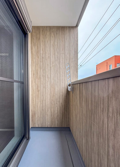 名古屋市北区の木造3階建てアパートの洗濯竿受けがついた木目調のインナーバルコニー