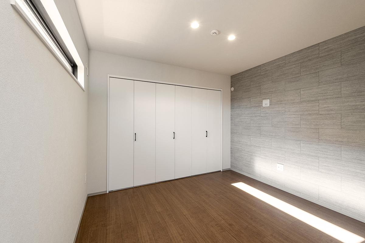 名古屋市北区の約60坪の土地の木造3階建てアパートの壁一面に収納があるモダンなデザインの洋室