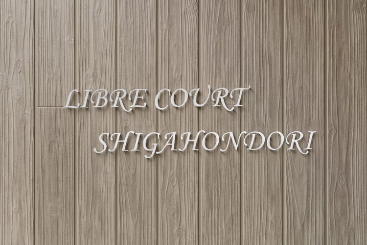 名古屋市北区の木造3階建てアパートの木目調の壁についたおしゃれな館銘板