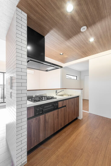 名古屋市北区の約60坪の土地の木造3階建てアパートの木目調パネルで高級感のある3口コンログリル付きのキッチン