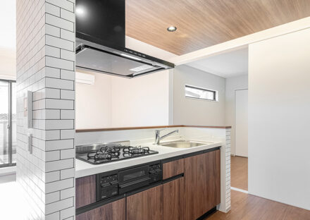 名古屋市北区の約60坪の土地の木造3階建てアパートの木目調パネルで高級感のある3口コンログリル付きのキッチン