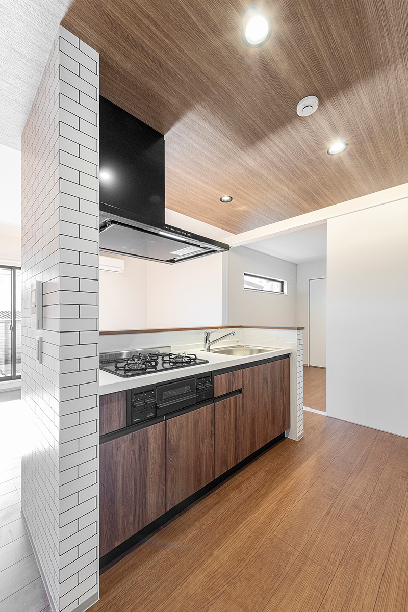 名古屋市北区の約60坪の土地の木造3階建てアパートの木目調パネルで高級感のある3口コンログリル付きのキッチン