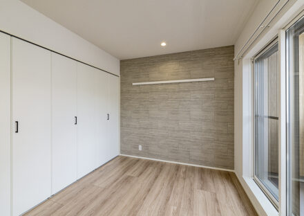 名古屋市北区の木造3階建てアパートのバルコニーからの光が感じられ壁一面に収納が付いた洋室