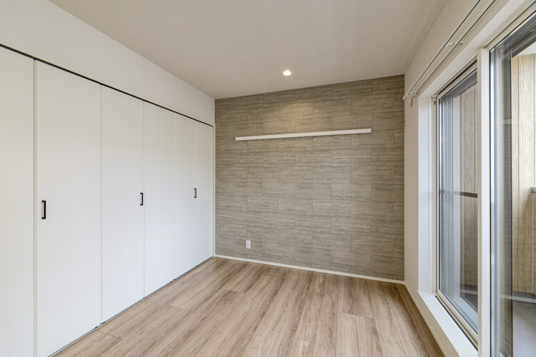 名古屋市北区の木造3階建てアパートのバルコニーからの光が感じられ壁一面に収納が付いた洋室