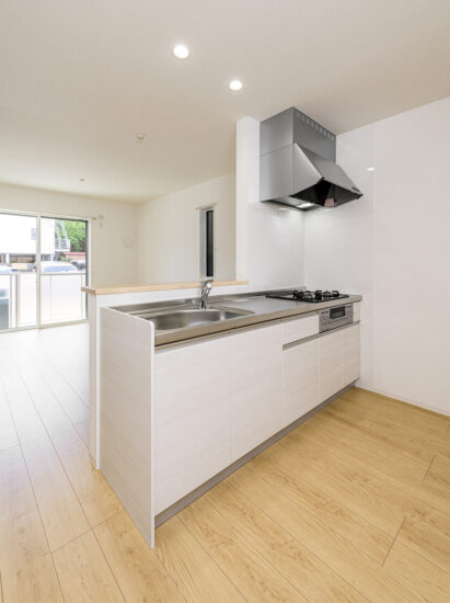 約40坪の土地のファミリー向けメゾネットアパートの3口コンロとグリルを備えた、家事効率を重視したシステムキッチン