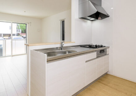 約40坪の土地のファミリー向けメゾネットアパートの3口コンロとグリルを備えた、家事効率を重視したシステムキッチン