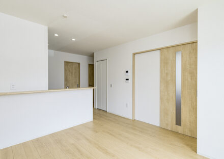 約40坪の土地のファミリー向けメゾネットアパートの階段下収納のあるナチュラルなリビング