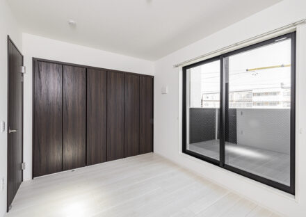 名古屋市北区の約300平米の土地活用：ゆとりある2棟の戸建賃貸のベランダ付きのフラットなクローゼットのドアがおしゃれな2階洋室