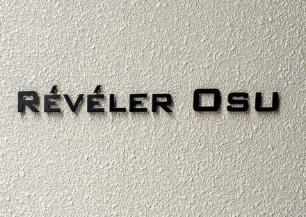 名古屋市中区の駅近・約70坪の土地の店舗付き賃貸マンションの壁面の質感とマッドブラックのコントラストを活かした、シンプルな館銘板