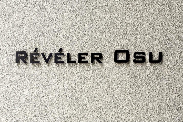 名古屋市中区の駅近・約70坪の土地の店舗付き賃貸マンションの壁面の質感とマッドブラックのコントラストを活かした、シンプルな館銘板