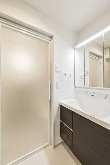 名古屋市中区の駅近・約70坪の土地の店舗付き賃貸マンション:Cタイプ:収納の多い木目調のパネルがおしゃれな洗面室