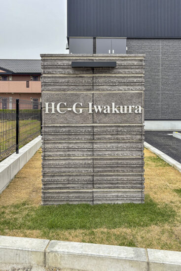 愛知県岩倉市の約300坪の土地のビルトインガレージ付きメゾネットアパートの重厚な背景にメタリックな文字が浮かぶ館銘板